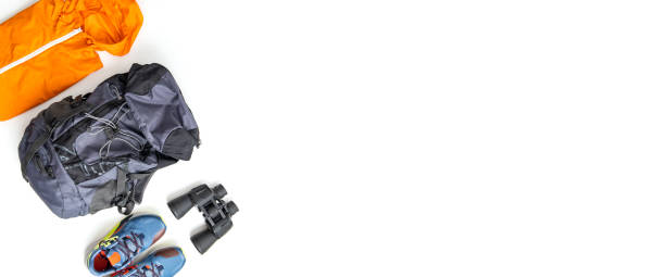 istock Raincoat, backpack, sneakers, binoculars on a white background. Top view, flat lay. Banner 1428989530