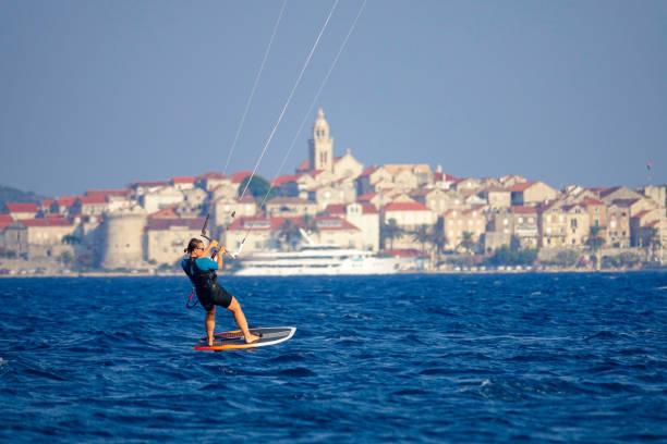 zbliżenie: fit młoda kobieta na aktywne wakacje foilsurfs z widokiem na korcula. - kiteboarding sunlight croatia dalmatia zdjęcia i obrazy z banku zdjęć