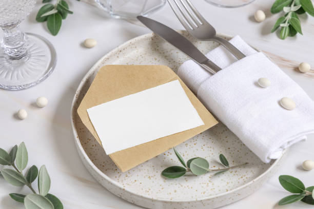 istock Elegant Table setting with a card decorated with eucalyptus branches close up, Wedding mockup 1428992008