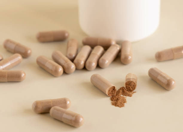 istock Opened Medical capsules on light beige close up. Taking dietary supplements 1428992024