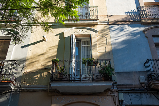 An old multi-story building balconies with potted plants. France.
