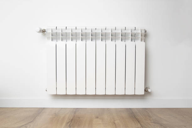 istock White heater hangs on a white wall. Central heating concept 1428993568