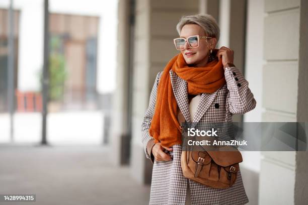 Smiling Woman Outdoor Portrait Short Blonde Hair Fashion Model Wears Stylish Clothes Doublebreasted Jacket Leather Handbag Ochre Knitted Scarf And Glasses Fashion Trend Of Autumn Or Spring Stock Photo - Download Image Now
