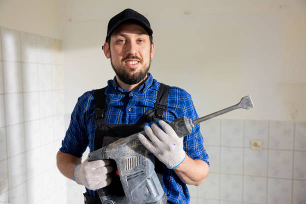 istock Satisfied worker performs home bathroom demolition, general apartment renovation with hammer, tile chipping, construction worker with experience 1428997050