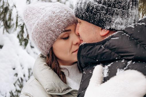 Young couple in love hugging in the winter forest and having fun spending time together.Winter,Valentine's day,newlyweds, tenderness and love.