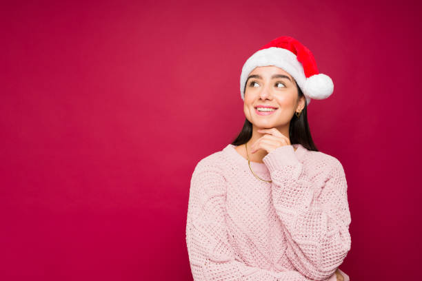 Pensive latin woman having christmas dreams and wishes stock photo