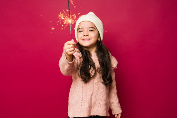 istock Adorable girl playing with a sparkle during christmas 1428998250