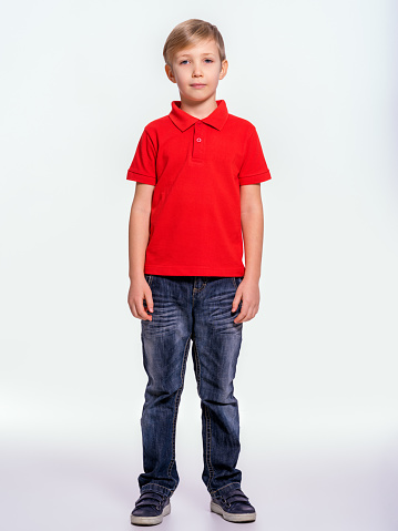 Smiling young boy standing against white background.