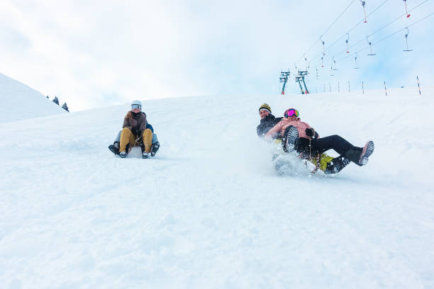 amici pazzi felici che si divertono con lo slittino sulle alte montagne innevate - st moritz engadine mountain winter foto e immagini stock