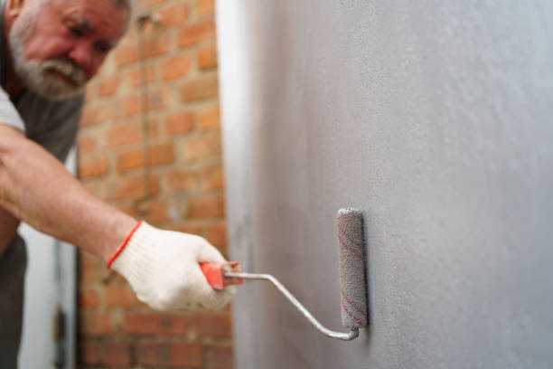 istock selective focus. an elderly man paints the metal garage door with a roller. 1429003322