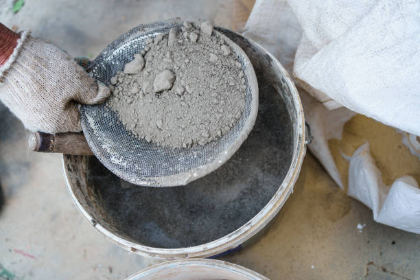istock men's gloved hands sift through the sand for the cement mortar. 1429004053