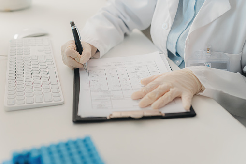 Scientist hands writing paper research, innovation and analytics for expert planning in science laboratory. Closeup of medical analysis document, doctor report notes and health clinic test results