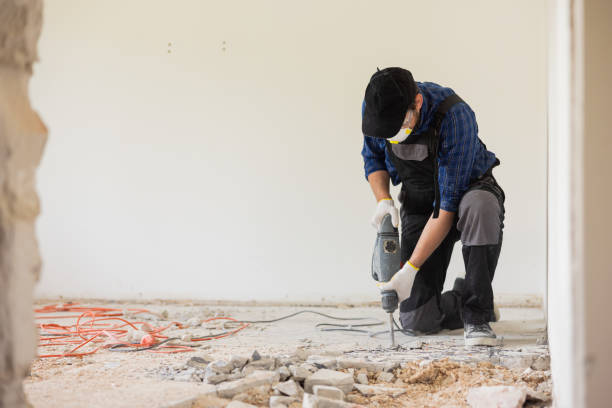 istock Removing a concrete floor with a hand hammer. Concrete rubble on the construction site of a house. Destruction of old tiles. Male construction worker fiercely working in overalls and protective mask 1429006120