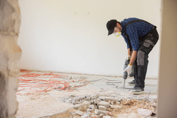 istock A man in a protective work suit wearing a mask and goggles is cupping the floor with a hand-held impact mote to prepare the space for tiles in the kitchen bathroom 1429006431