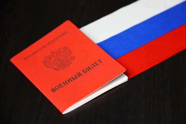 Russian military ID and national flag on wooden table stock photo