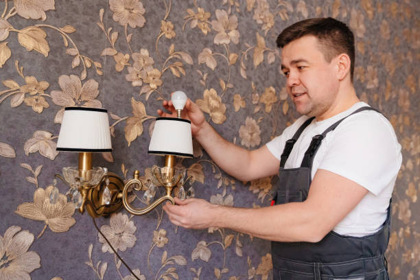 istock A male electrician changes the light bulbs and repairs in the sconces 1429007578
