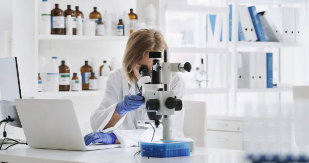 Doctor, science and research woman with microscope, laptop and technology for innovation, education and futuristic analytics. Nurse, professional and medical worker working with medicine data in lab.