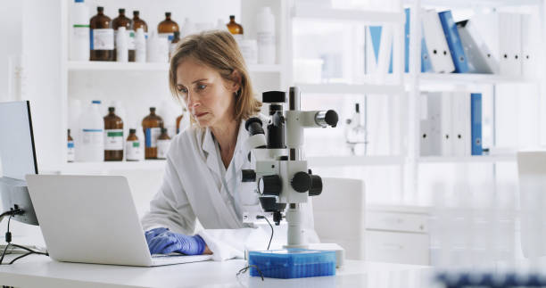 istock Expert scientist doing research with a laptop and biotechnology equipment in pharmaceutical lab. Science chemist working on a medicine innovation with computer and microscope in a medical laboratory. 1429007675
