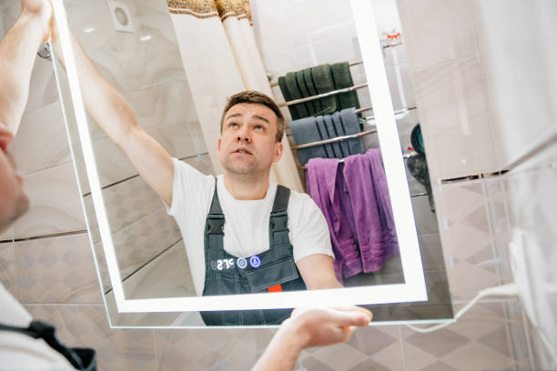 istock repairman hangs a modern electronic bathroom mirror. 1429007883
