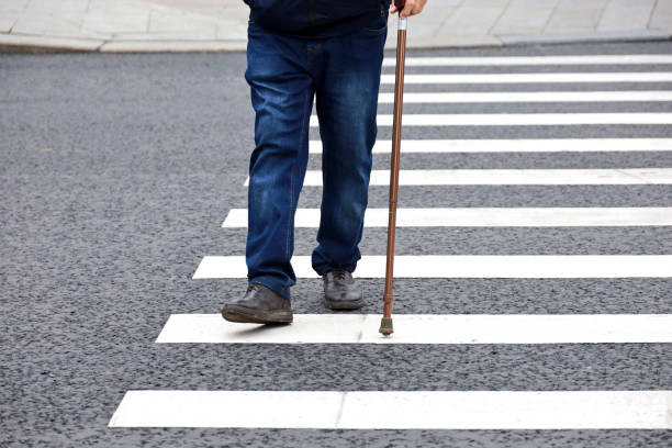 istock Man walking with a cane on crosswalk 1429008837