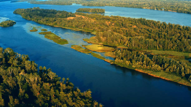 istock Beautiful summer landscape while sunset over the river with a drone. Aerial view on a green wild nature landscape. Beautiful  lake with small islands - drone shooting. 1429013459