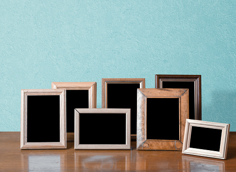 wooden photo frames on table, blue wall