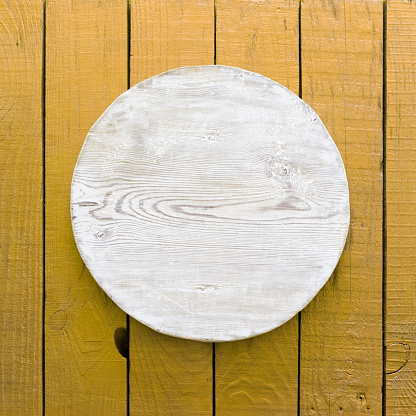 grunge empty round wooden plate on old wooden table, background with copyspace