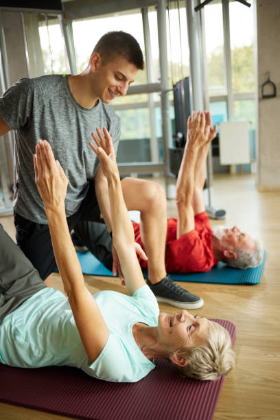 istock Senior couple doing exercises with personal trainer at the gym 1429025698