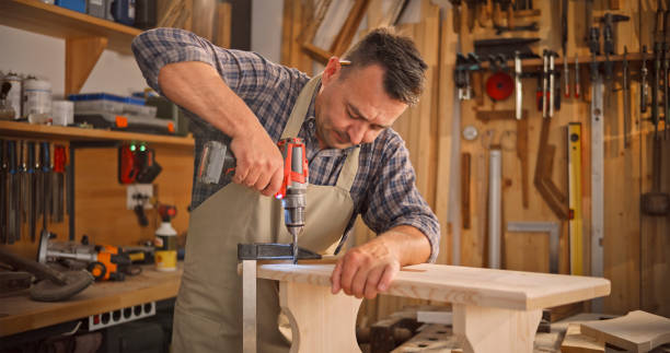 istock Male carpenter drilling wooden plank 1429027974
