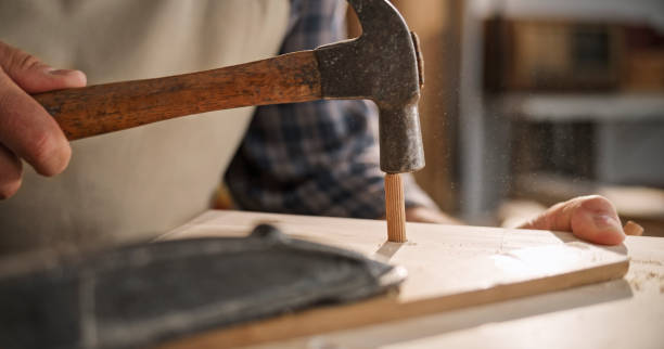 istock Male carpenter hitting wooden nail on plank 1429028005
