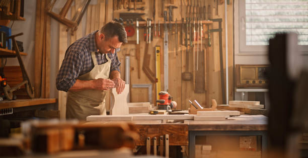 istock Male carpenter sanding wooden plank 1429028617
