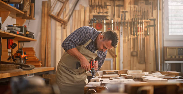 istock Male carpenter drilling wooden plank 1429028654