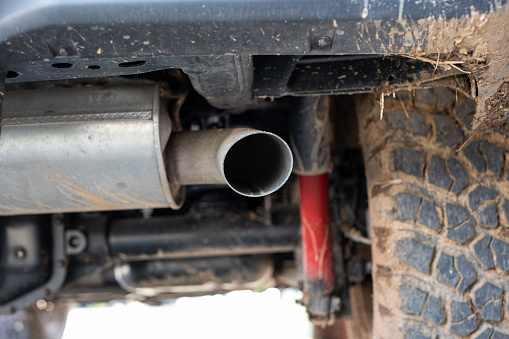 SUV car exhaust muffler or resonator and tip. Low angle view, no people.