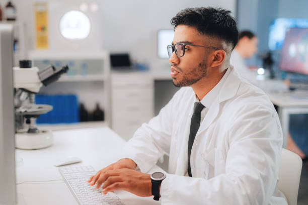 istock Science man and lab research with computer for medical innovation and analysis notes for test cure. Scientist worker with phd typing medicine development data for vaccine in workplace. 1429037932