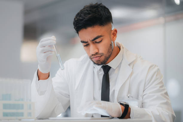 istock Scientist, tablet and research for medical chemical in test tube while doing data analysis or reading result for medicine experiment in lab. Laboratory, biotechnology male and vaccine development 1429038131