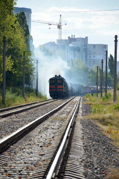 il treno merci è guidato da una locomotiva diesel. ferrovia in città - diesel locomotive foto e immagini stock