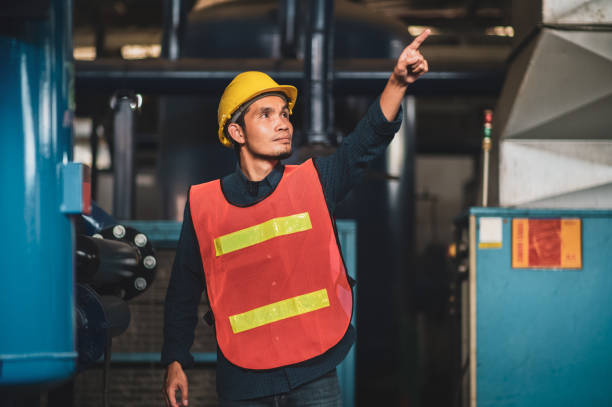 istock Asian construction site manager standing wearing safety vest and helmet, thinking at construction site. Portrait of Indonesian manual worker or architect with satisfaction. 1429054530
