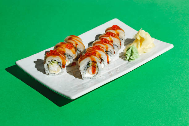 istock Sushi rolls with eel, shrimp, cucumber and cream cheese, decorated with red caviar. Hard light, deep shadow 1429058671