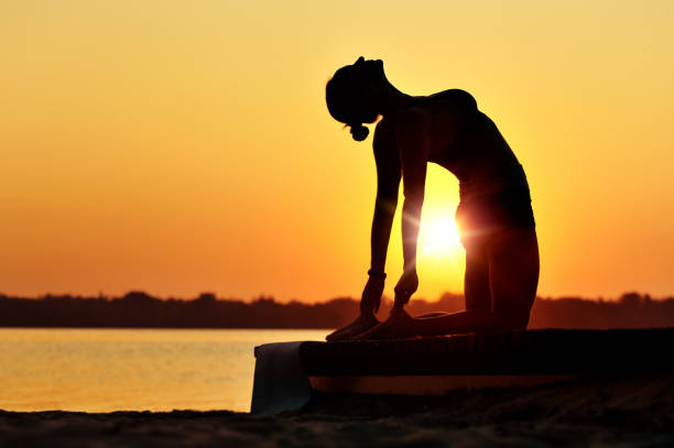istock Woman making stretching exercises at the sunset yoga practice 1429062279