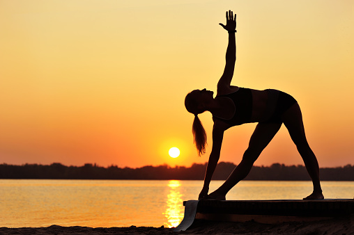 Sporty woman practicing yoga triangle yoga pose silhouette picture