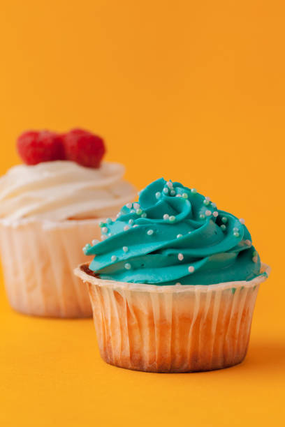istock Delicious cupcakes with icing on a yellow background 1429064786