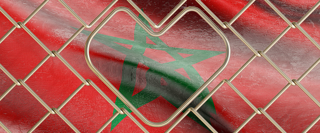 3D render of an old moroccan flag behind steel mesh wire fence.  the flag of morocco with a heart in the middle.