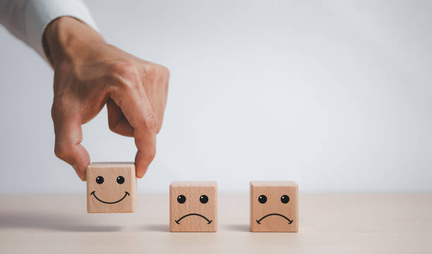 istock Customer service evaluation and satisfaction survey service rating concepts.Hand choose wooden cube block with icon face smile, Close up customer hand choose the happy face smile face icon on wooden. 1429069063