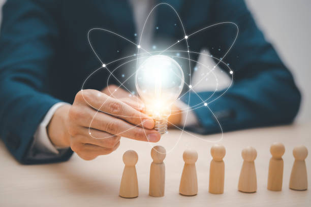 istock Man hand holding light bulb with Business icon on wood cube and working on desk, Creativity, and innovation are keys to success. Concept of new idea and innovation with Brain and light bulbs. 1429069507