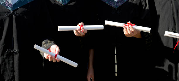istock people in a gown holding a diploma. 1429070079