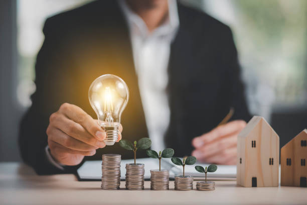 istock Businessman hand holding light bulb on coins stack on the wooden table , Saving ideas and investment budget, Creative ideas concept of saving money  concept, Copy space 1429071285