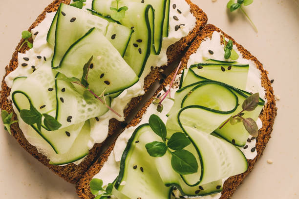 istock Breakfast, cereal bread sandwiches, cream cheese, sliced cucumber, with micro greenery on a light table, close-up, top view, selective focus, no people, 1429072483
