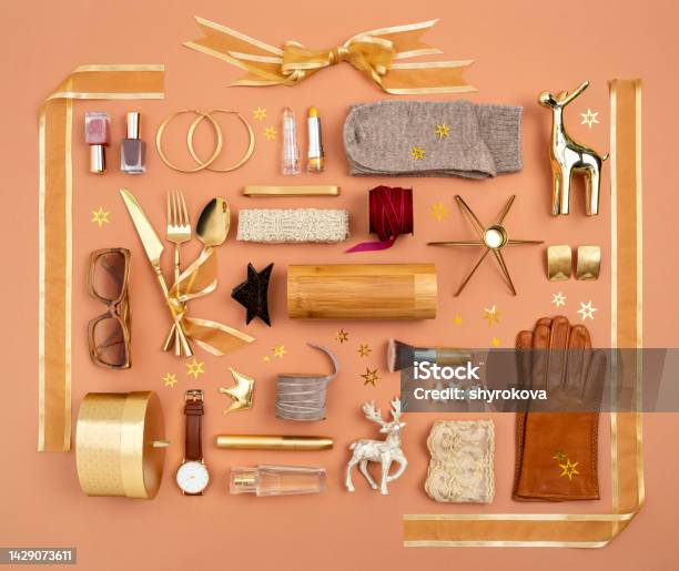 Christmas Objects Gifts And Decorations Laid Out In The Shape Of A Gift Box With Golden Ribbon And Bow Accessories Makeup And Cosmetics As A Presents Ideas Gifts Guide For Her Overhead View Stock Photo - Download Image Now