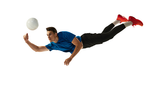 Studio shot of young man, volleyball player in sports uniform playing volleyball isolated on white studio background. Sport, gym, team sport, challenges. Copy space for ad