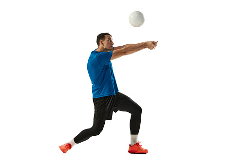 Receiving the ball. One volleyball player training with ball isolated on white studio background. Sport, gym, team sport, challenges. Athlete playing volleyball